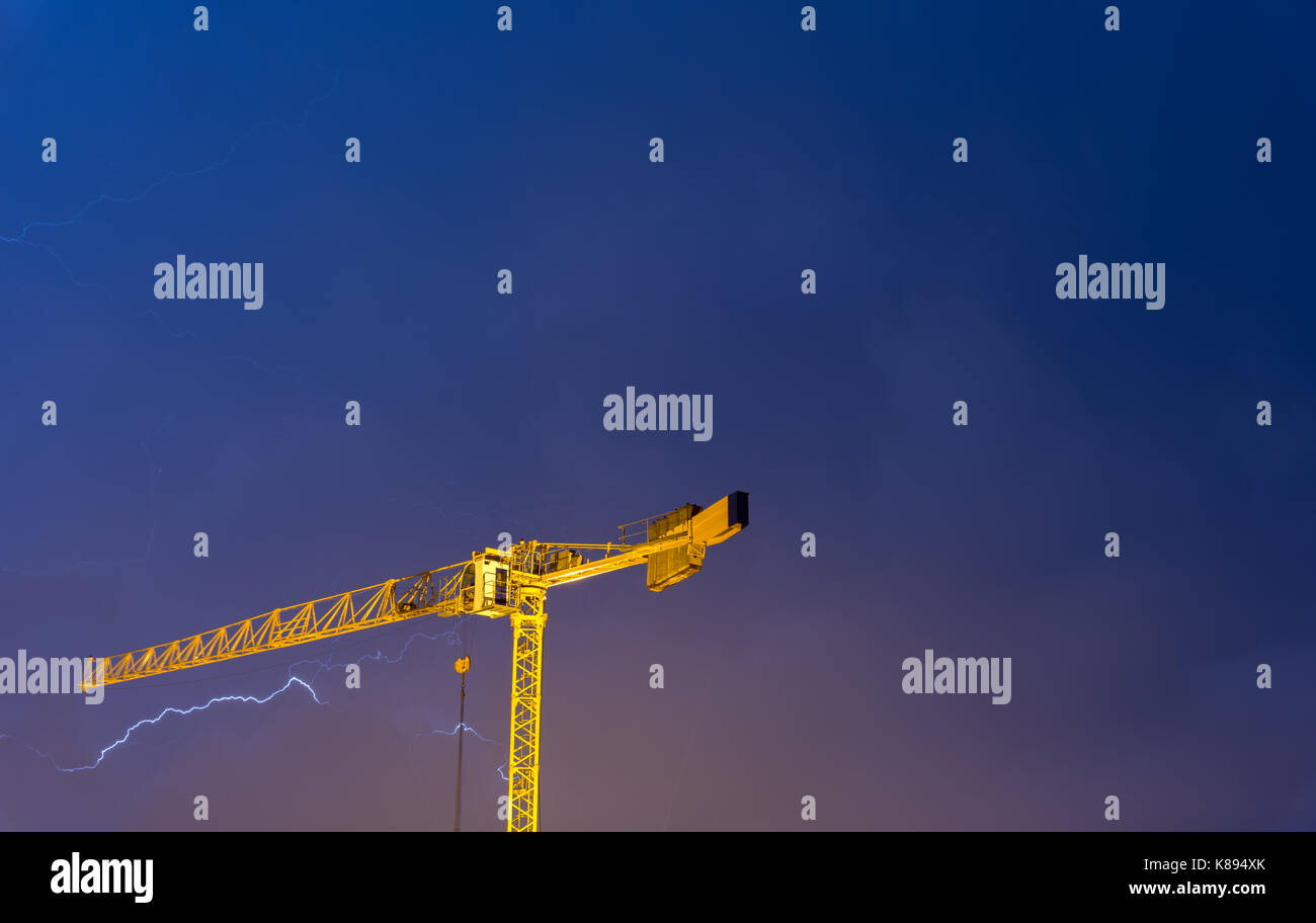 crane struck by lightning, powerful thunderbolt on a stormy night Stock
