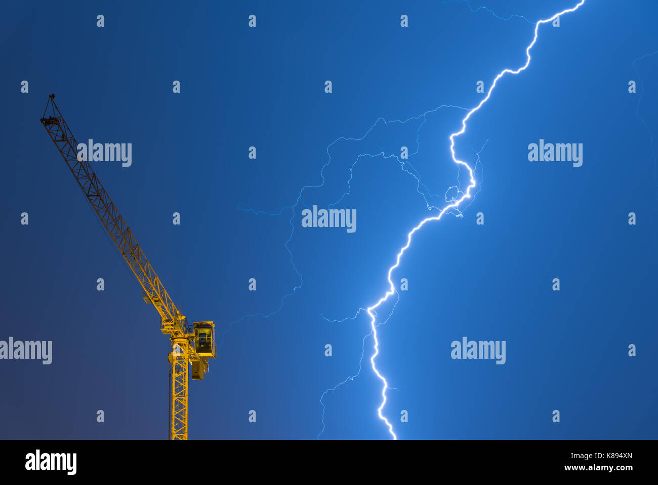 crane struck by lightning, powerful thunderbolt on a stormy night Stock