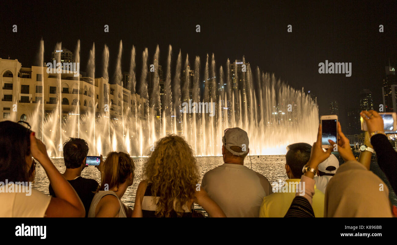People at the The Dubai Fountain, the world’s second largest choreographed fountain with a breathtaking show of sights and sounds. Stock Photo