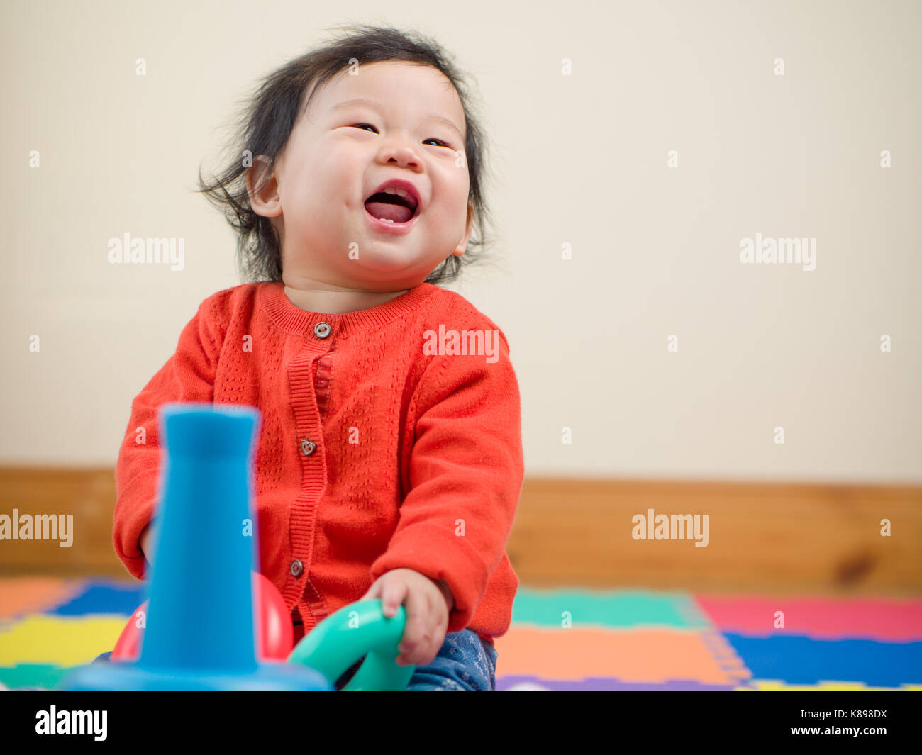Asian baby girl playing toy in home Stock Photo - Alamy