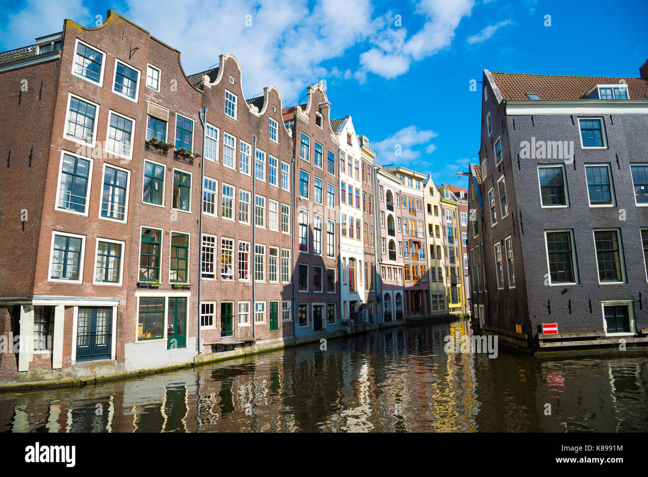 Amsterdam, Netherlands - April 19, 2017: Classical view of traditional buildings at the canal side in Amsterdam downtown. Amsterdam, Netherlands. Stock Photo