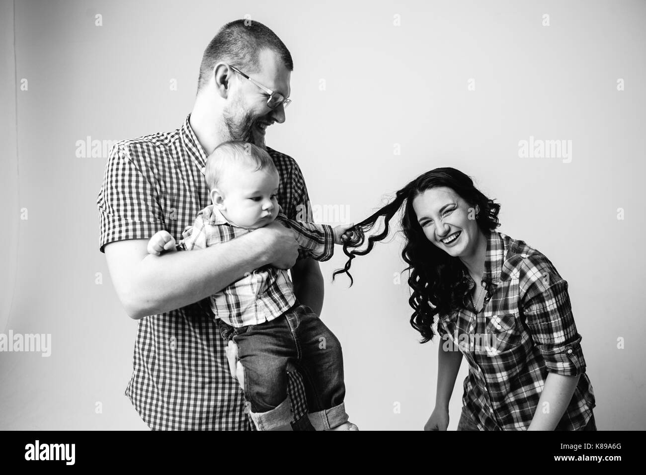 joyful parents and small kid laughing and playing Stock Photo