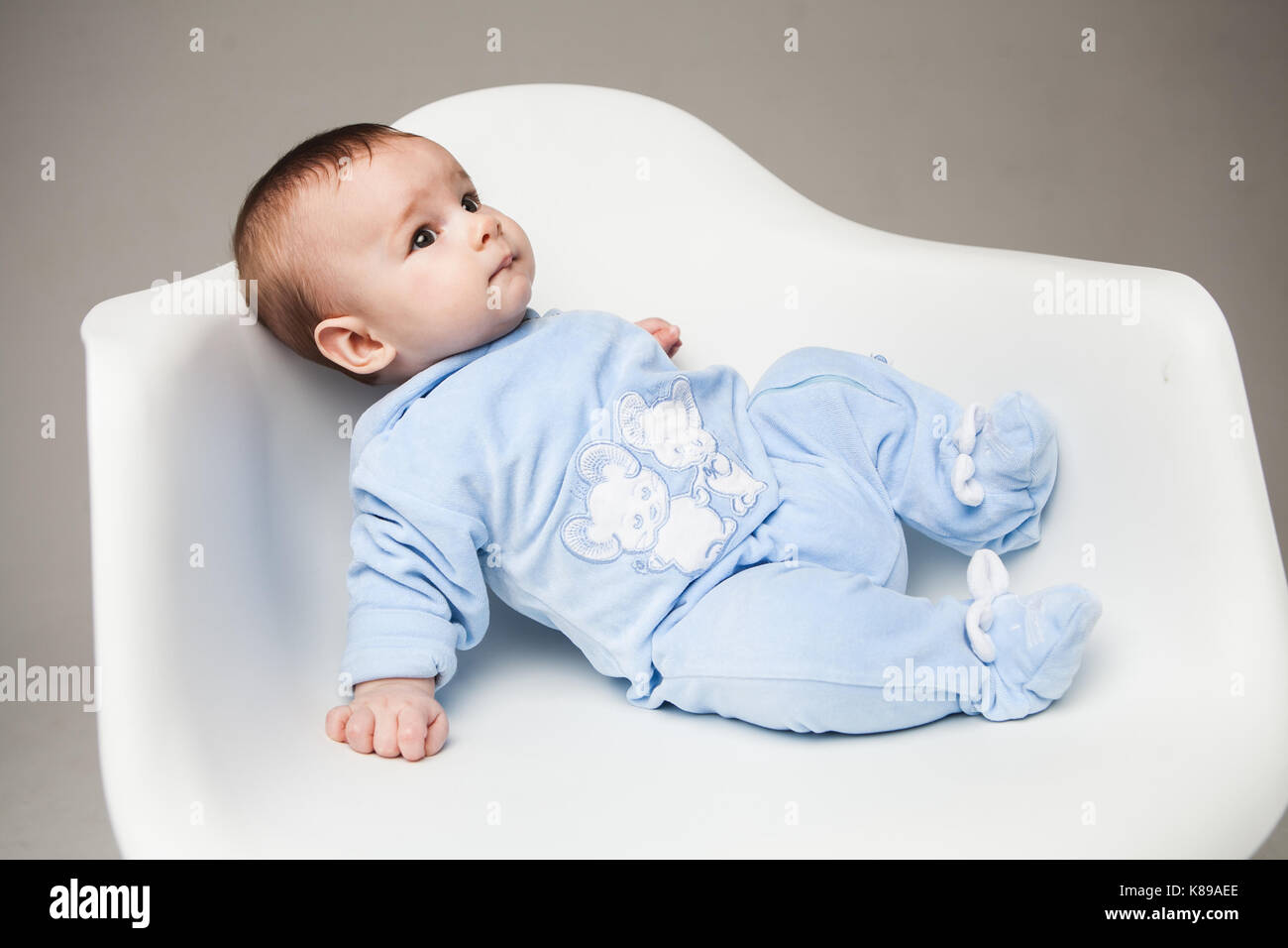 boy one year old sitting on chair studio portrait white background Stock Photo
