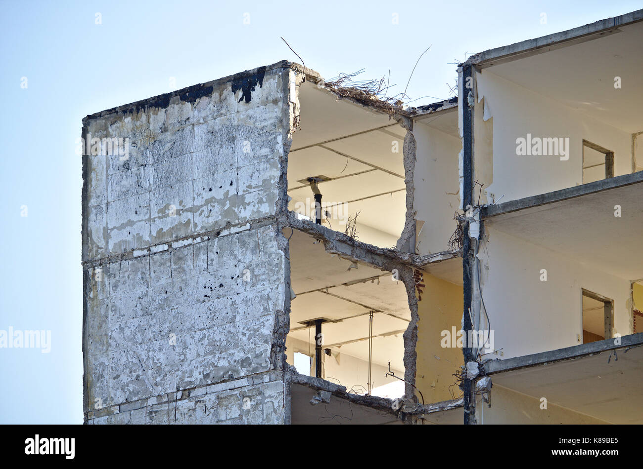Upper floor of a derelict residential building in the process of being demolished with large holes in the walls Stock Photo