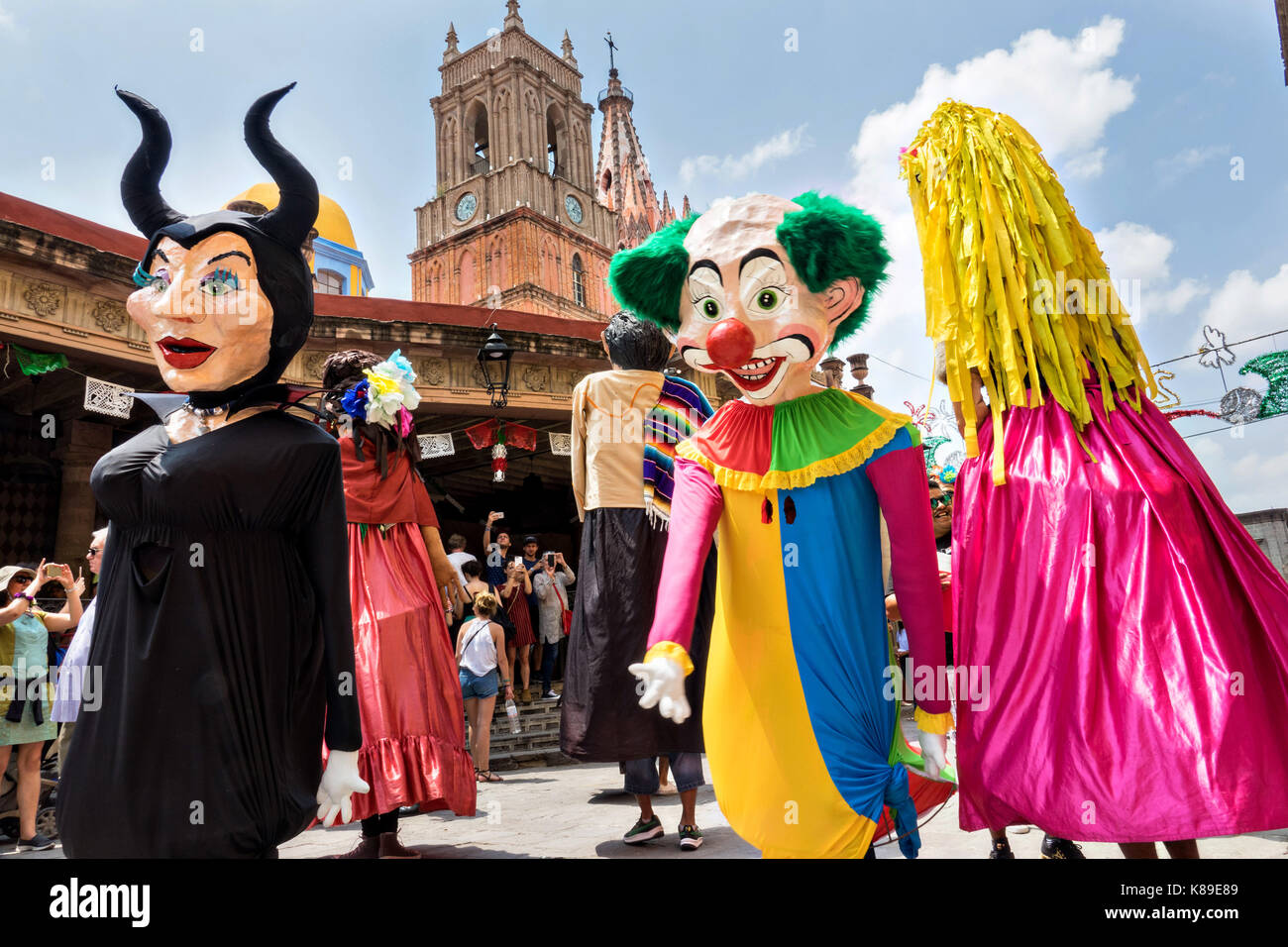 Giant papier mâché puppets called mojigangas dance in front of the