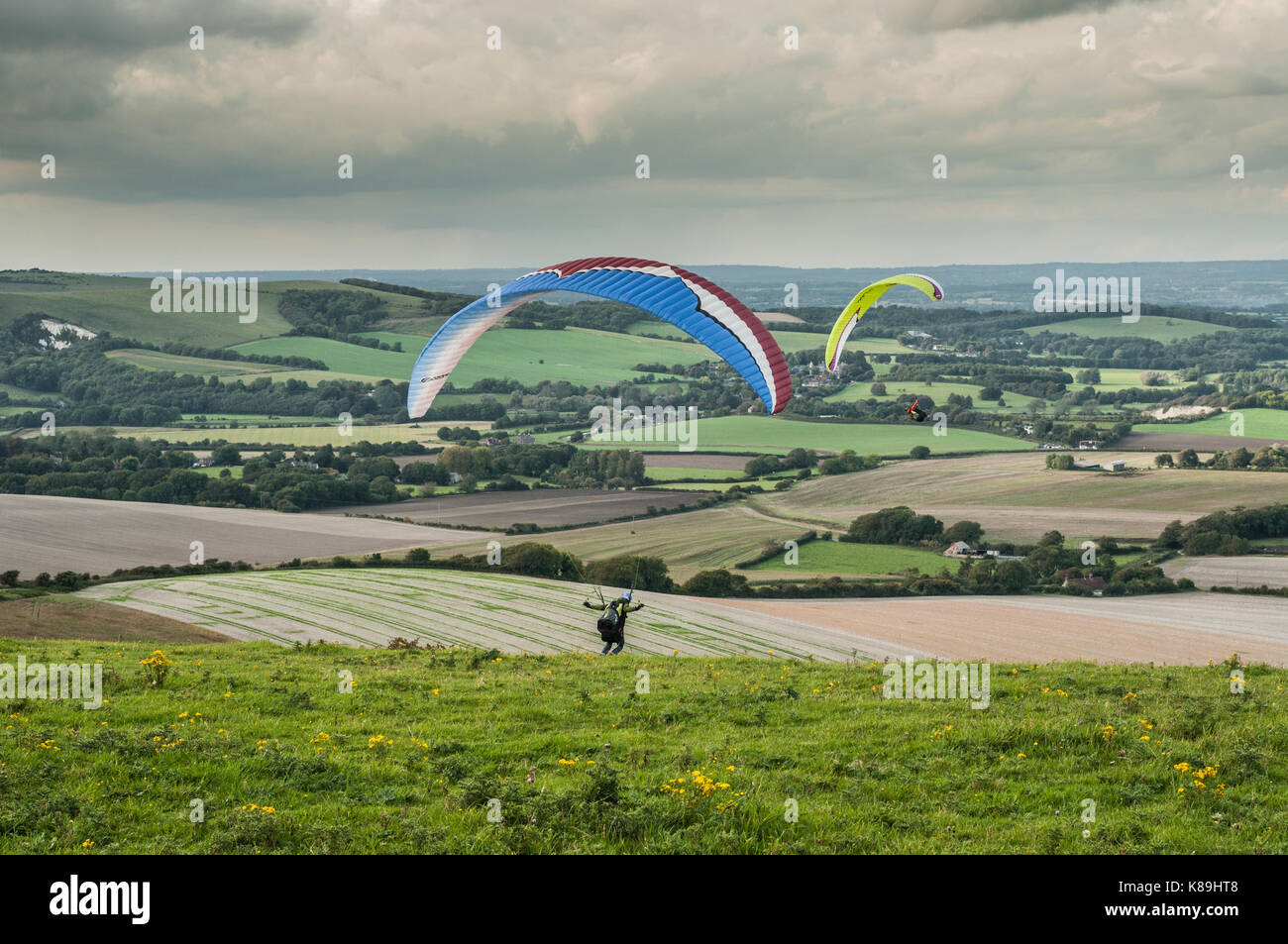 Firle Beacon, Lewes, East Sussex, UK. 18th Sep, 2017. UK Weather. Paraglider pilots on the South Downs of Southern England flying from the Beacon (Marilyn) on the Northerly wind. Scattered clouds with showers but a most pleasant afternoon. Stock Photo