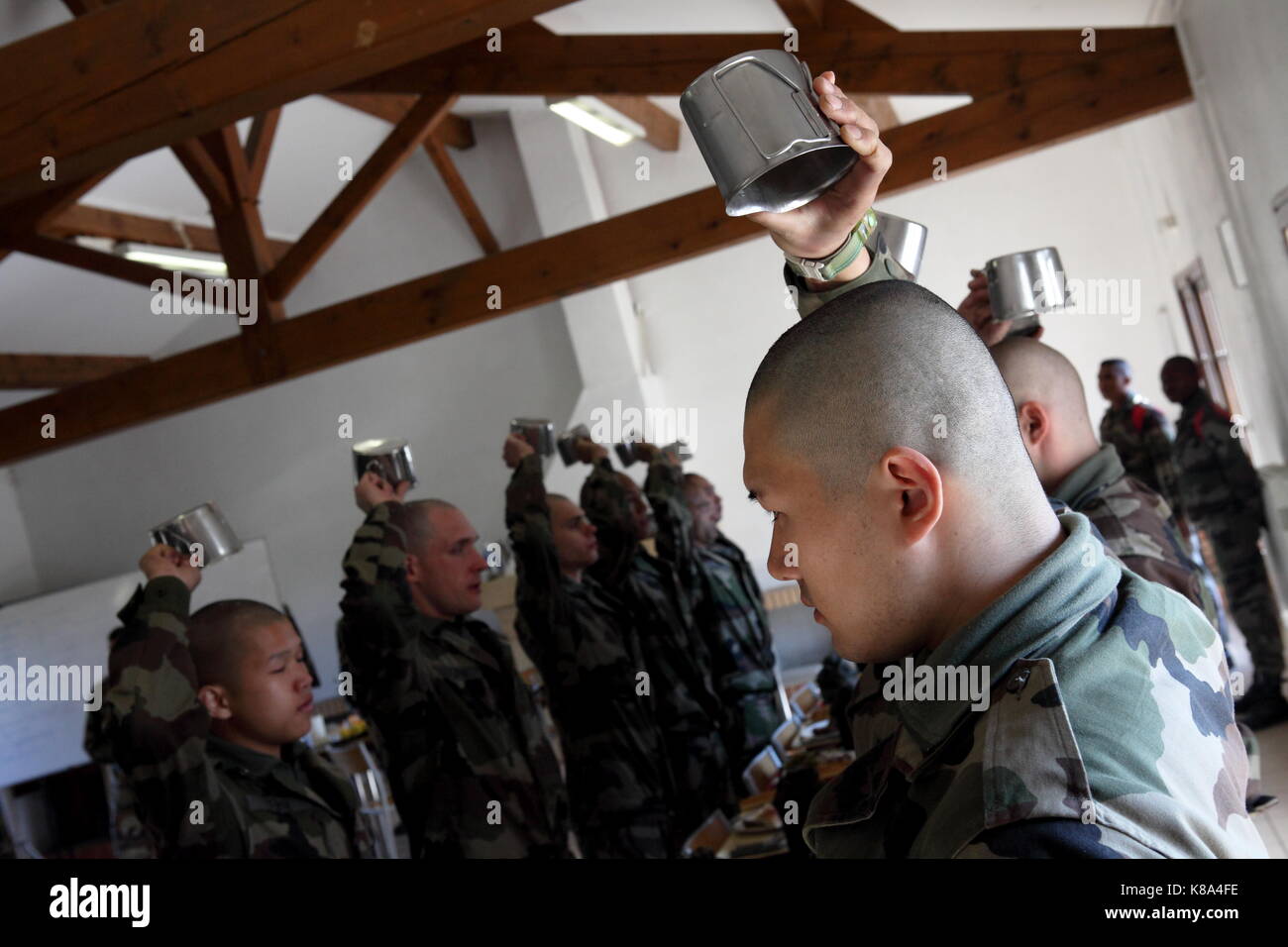 French Foreign Legion recruits (Engagé Volontaires), not quite yet Legionnaires, raise their canteen cups at the 4REI, 2CIE's farm outside Castelnauda Stock Photo