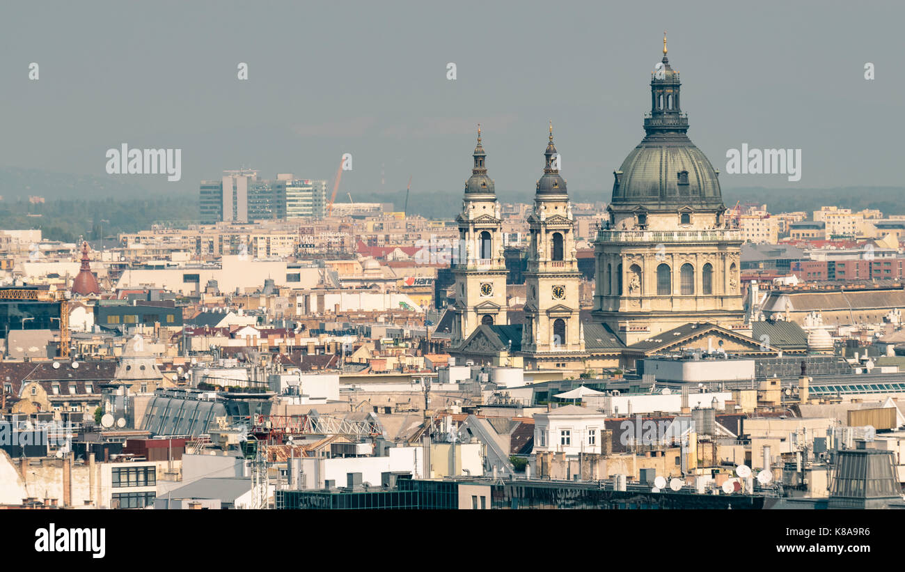 Great view over the rooftops of Budapest in Hungary with the prominent dome and towers of the St Stephens Basilica rise above the rest. Stock Photo