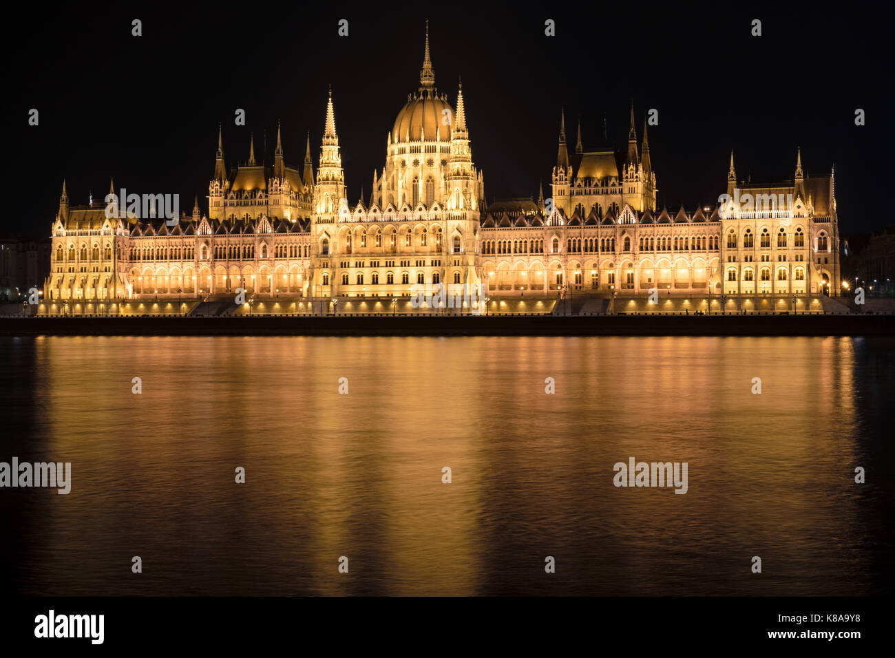 Night shot of the Hungarian Parliament Building with beautiful golden reflections in the water of the Danube in Budapest, Hungary. Stock Photo