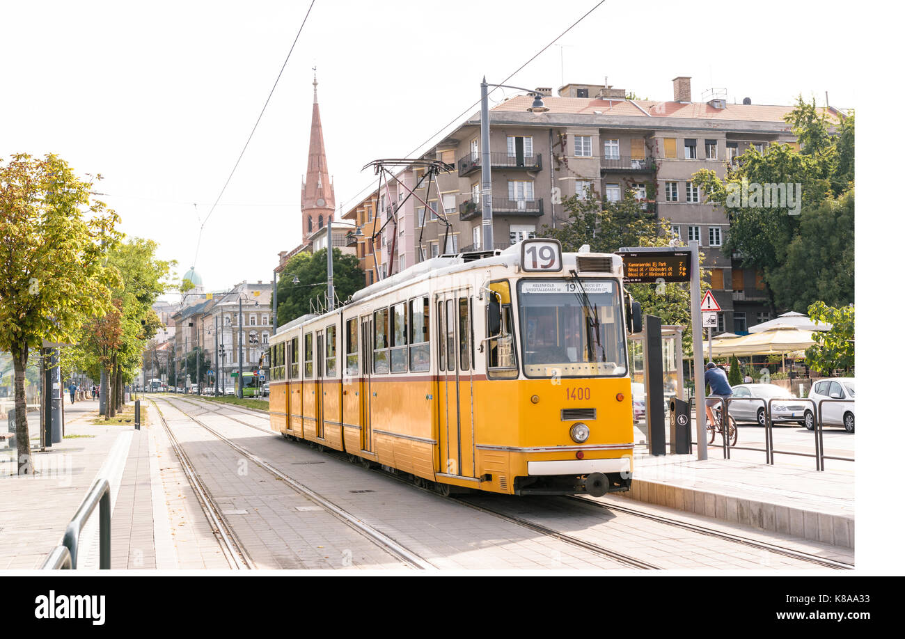 Image of one of the old yellow trams in Budapest, Hungary, stopping at a station. Stock Photo