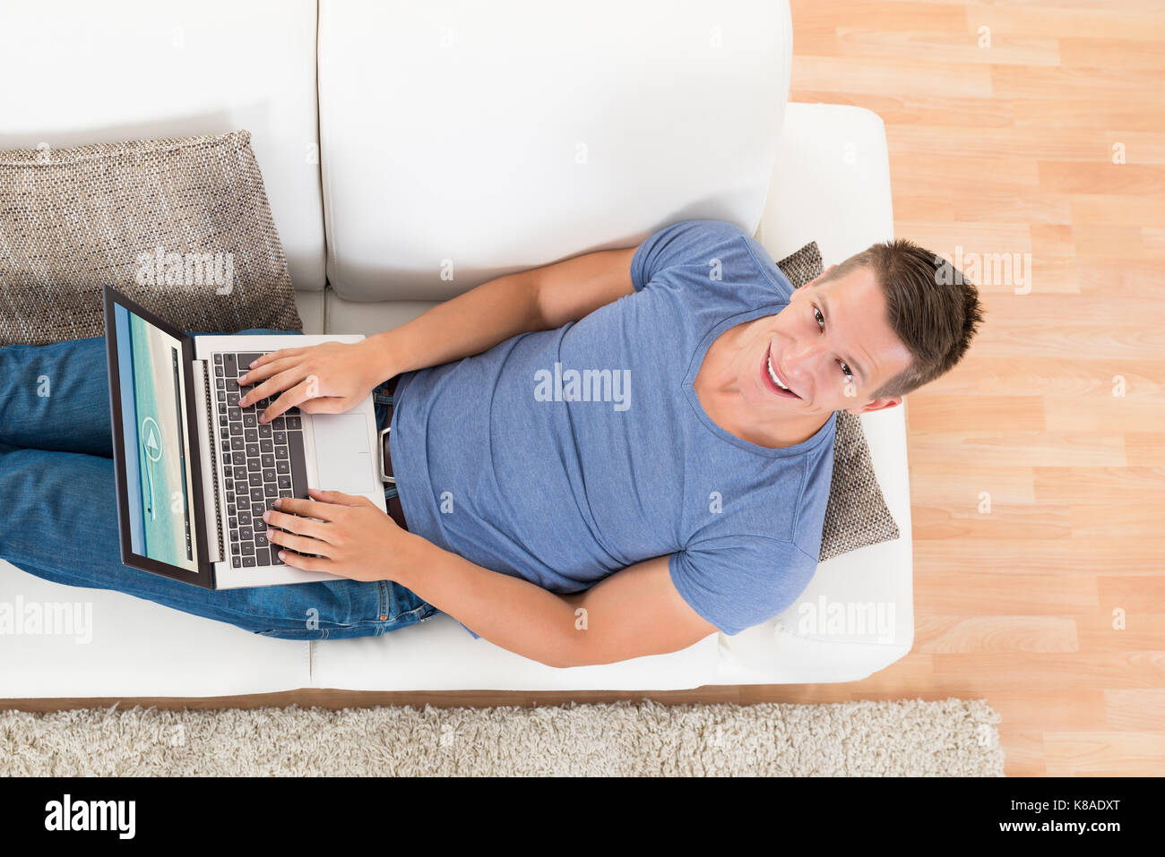 High Angle View Of Young Man Watching Video On Laptop At Home Stock Photo