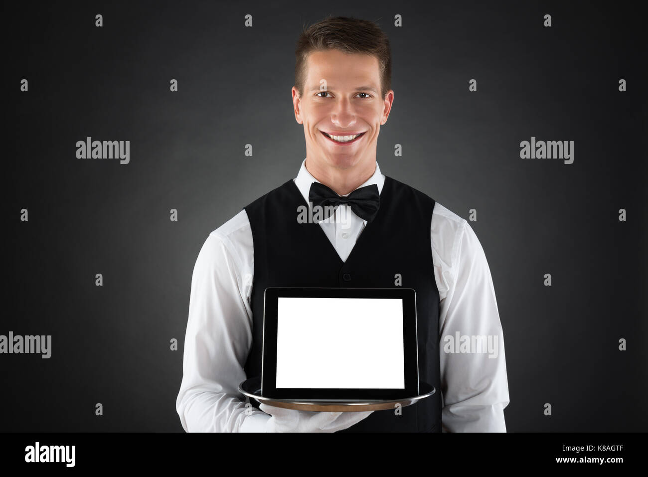 Young Butler Holding Tray With Blank Display Digital Tablet Stock Photo