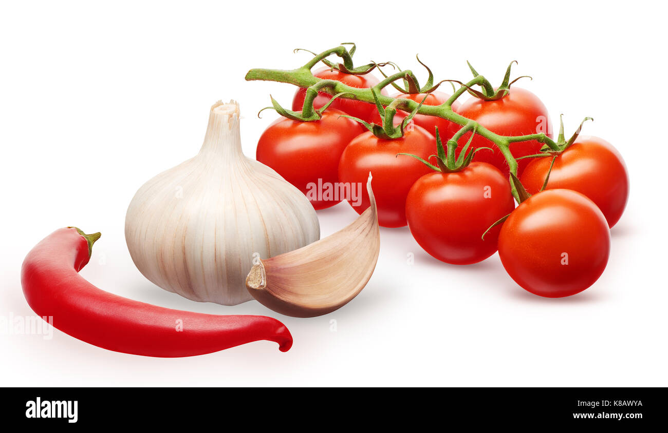 Branch of fresh red cherry tomatoes with green leaves, garlic with clove and red chili pepper vegetables isolated on white background Stock Photo