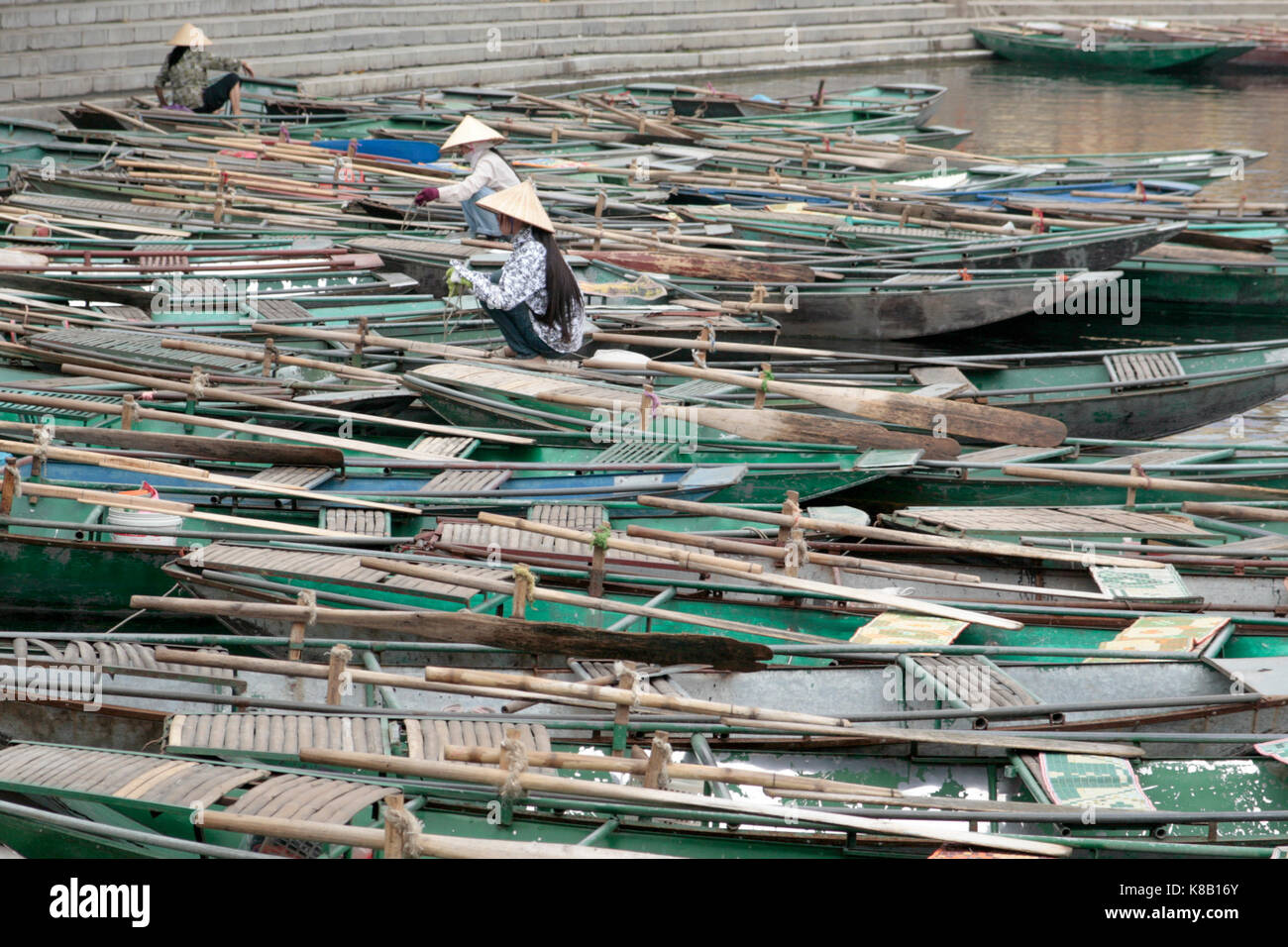The jumble of boats waiting for visitors at the dock at Trang An for a trip through the caves. Stock Photo