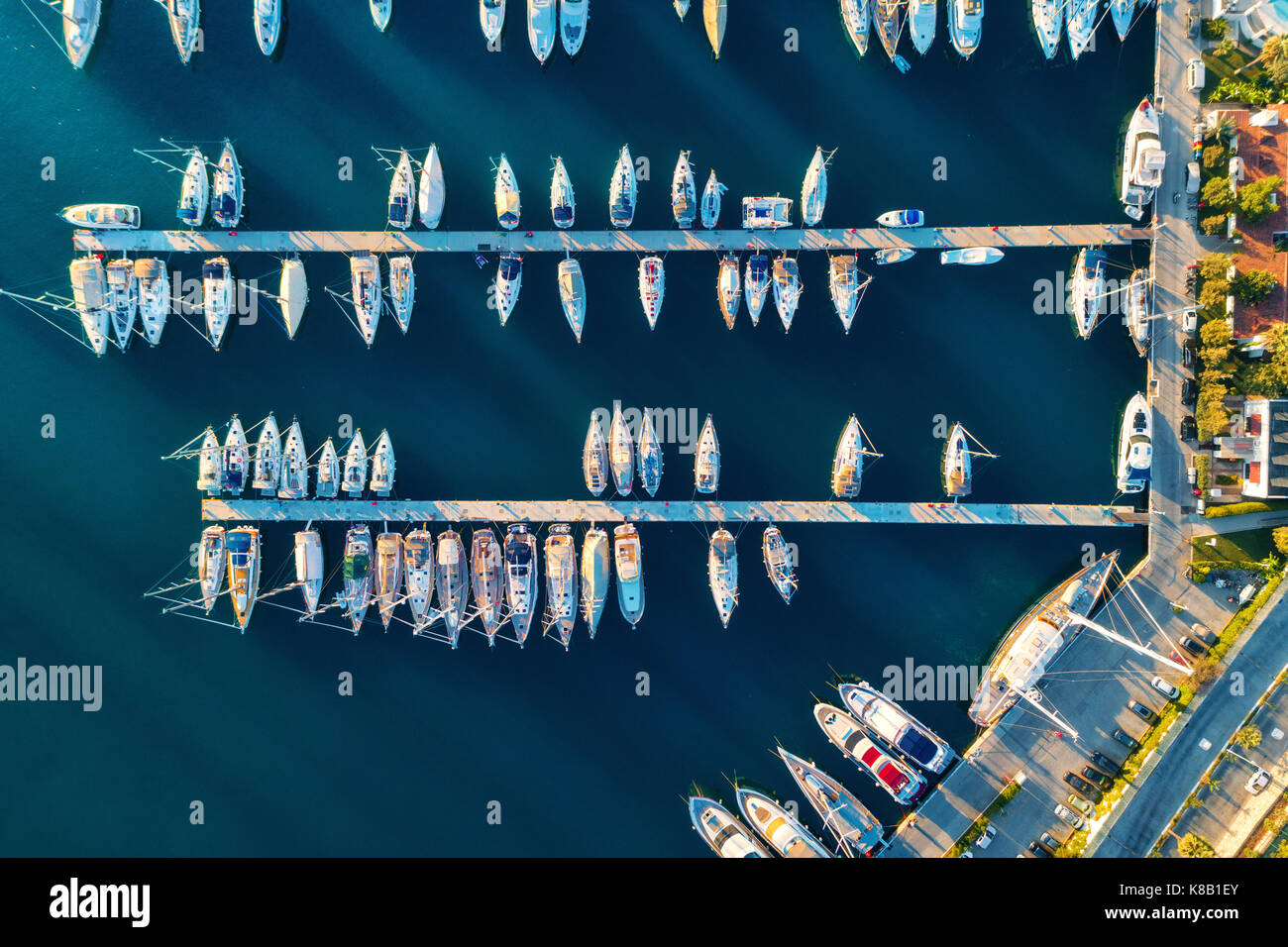 Aerial view of amazing boats at sunset in Marmaris, Turkey. Minimalistic landscape with boats and sea in marina bay. Top view from drone of harbor wit Stock Photo