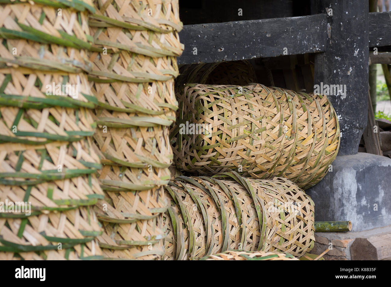 Close up of a stack of Indonesian traditional hand made hand woven bamboo baskets with part made one in the back ground. Stock Photo