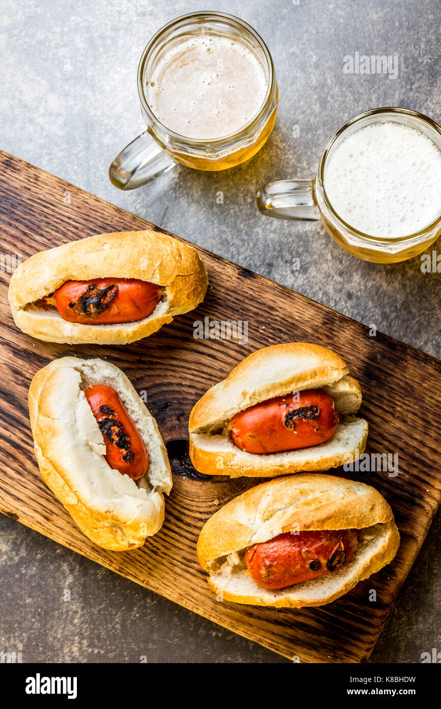 Choripan. Latin American Argentine and chilean food. Chorizo sausages hot dogs served with beer, top view. Stock Photo