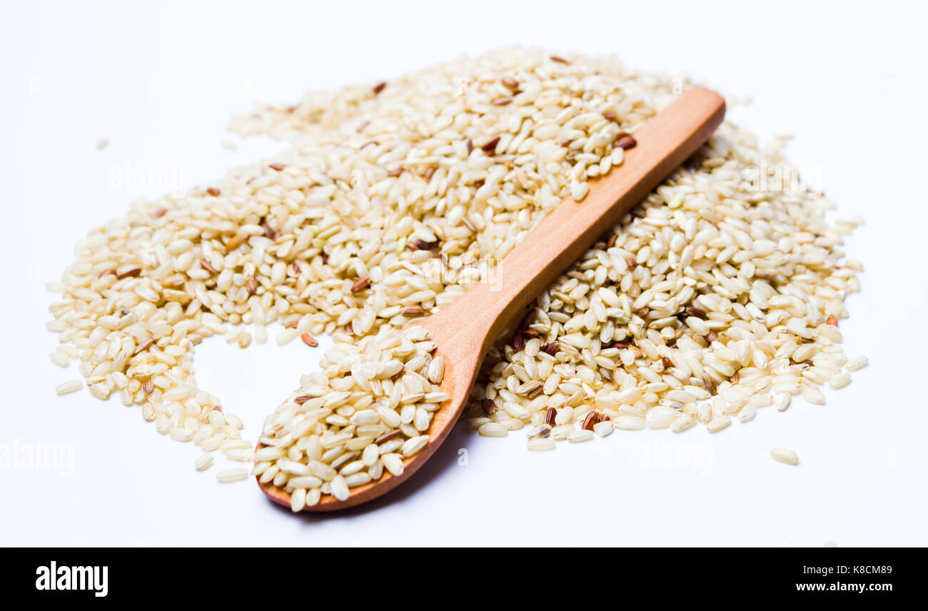 Yellow rice seeds in a wooden spoon isolated Stock Photo