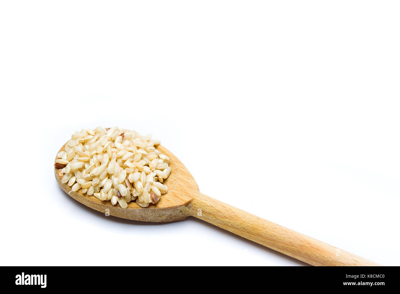 Yellow rice seeds in a wooden spoon isolated Stock Photo