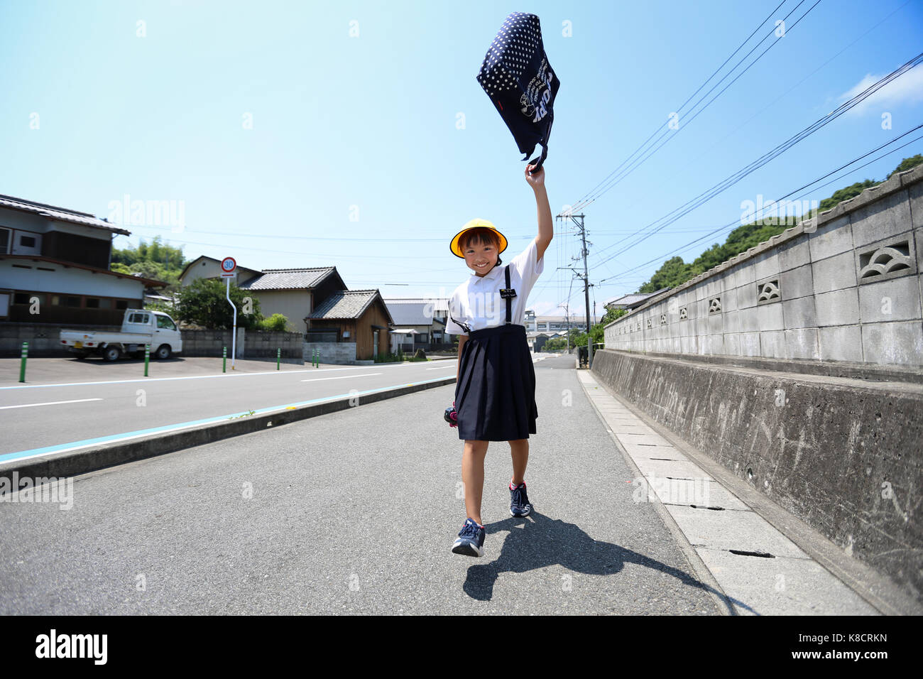 Elementary School Girl Walking on Road Stock Photo