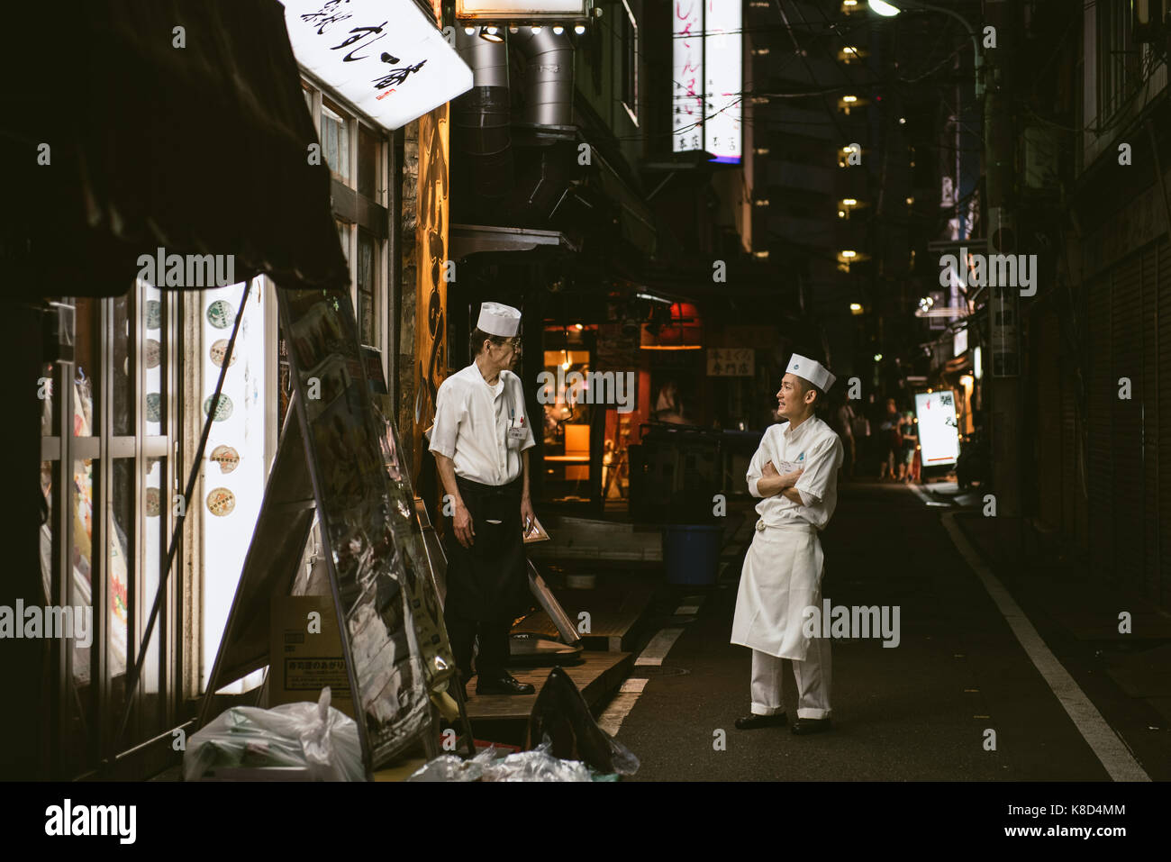 Sushi chefs taking a break in the evening at Tsukiji fish market, Tokyo, Japan. Stock Photo