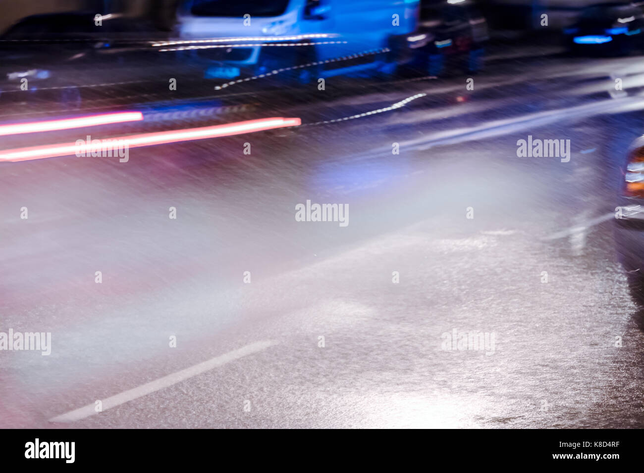 blurred red headlights of car driving on flooded road during heavy rain at night Stock Photo Alamy