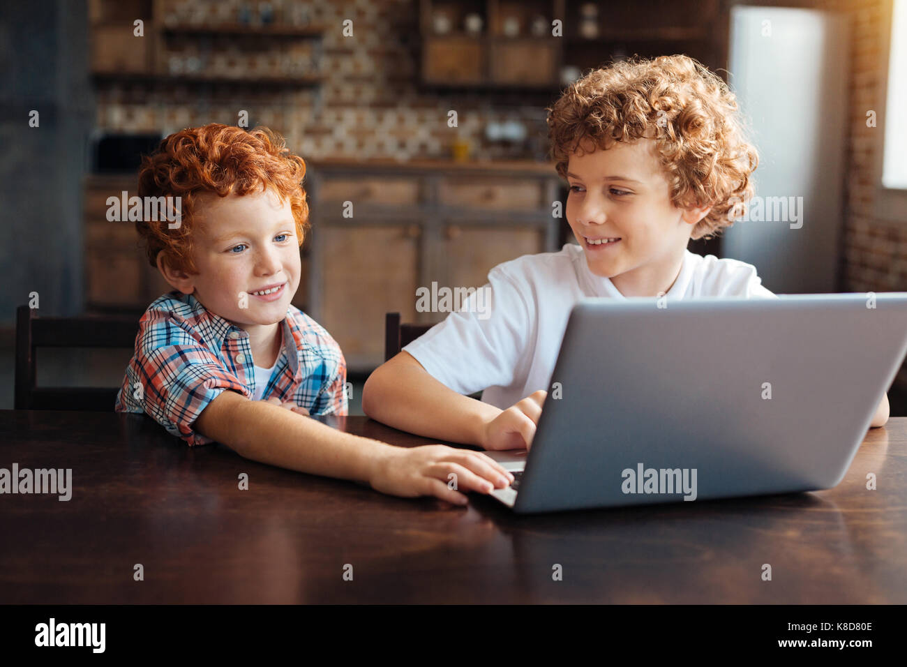 Cheerful kids playing on laptop together Stock Photo - Alamy