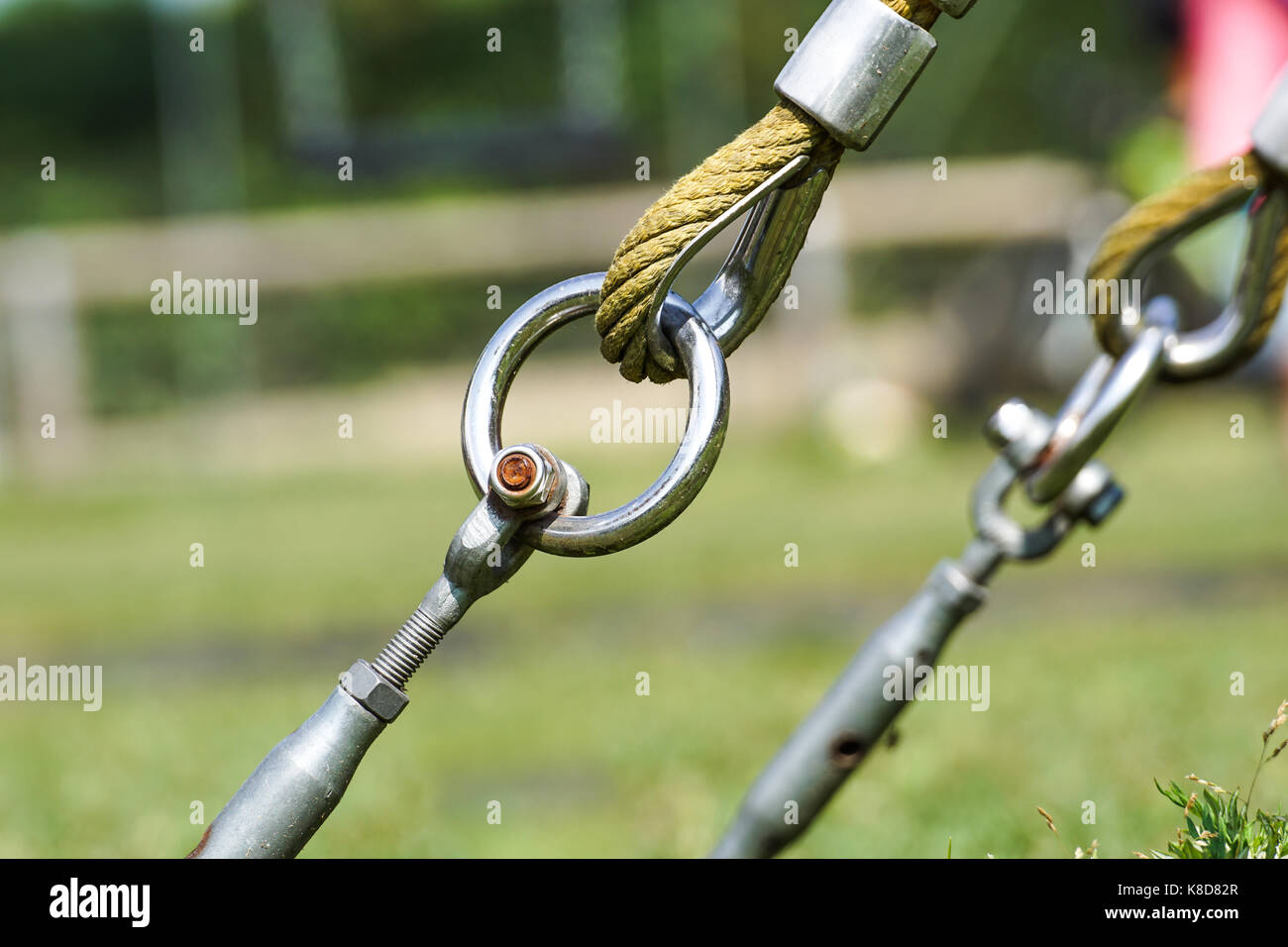 End of swinging rope hang on metal construction in a park. Rough rope ...
