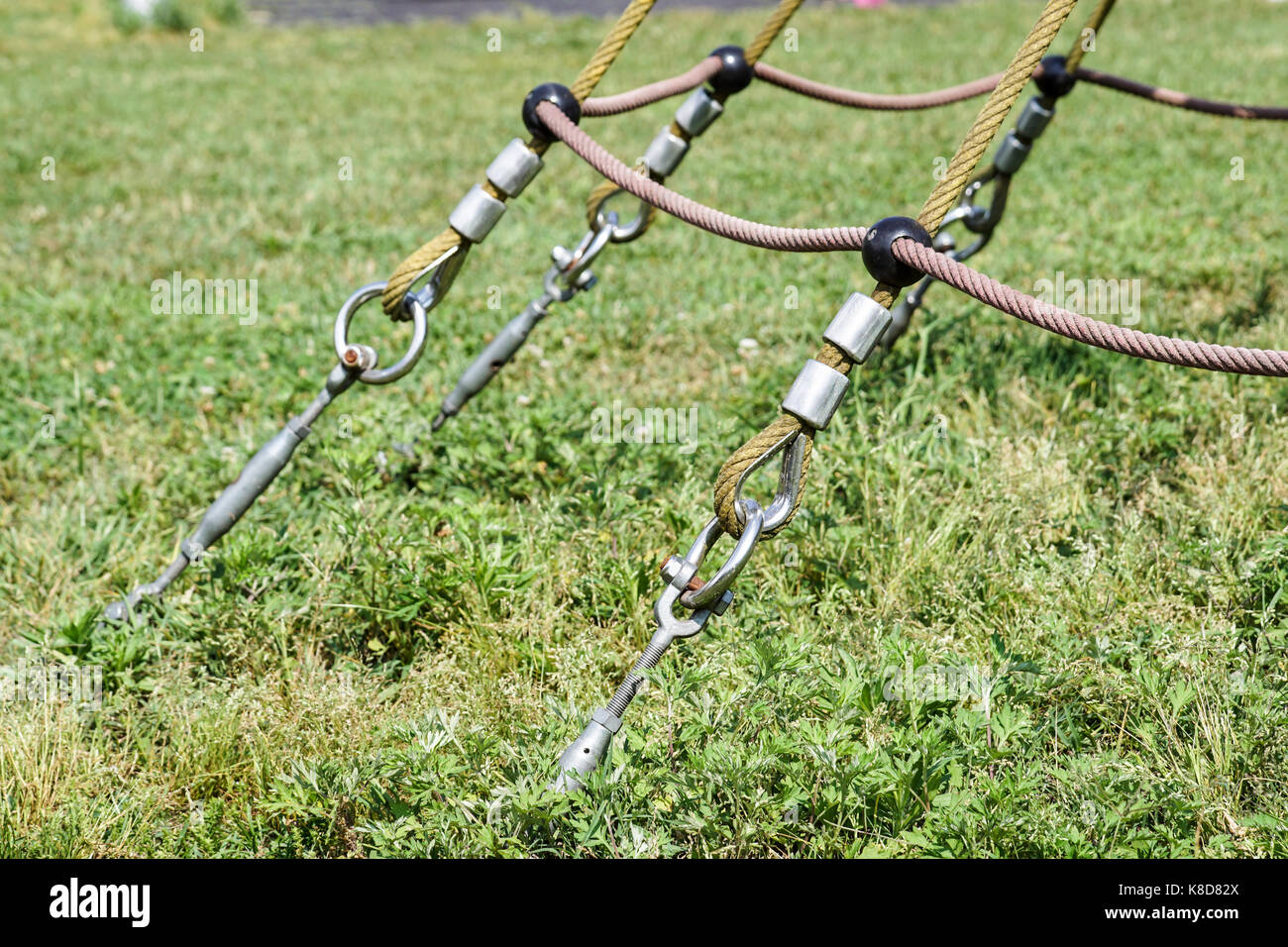 End of swinging rope hang on metal construction in a park. Rough rope ...