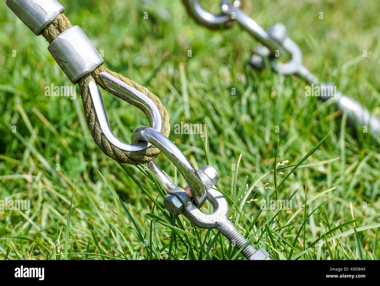End of swinging rope hang on metal construction in a park. Rough rope