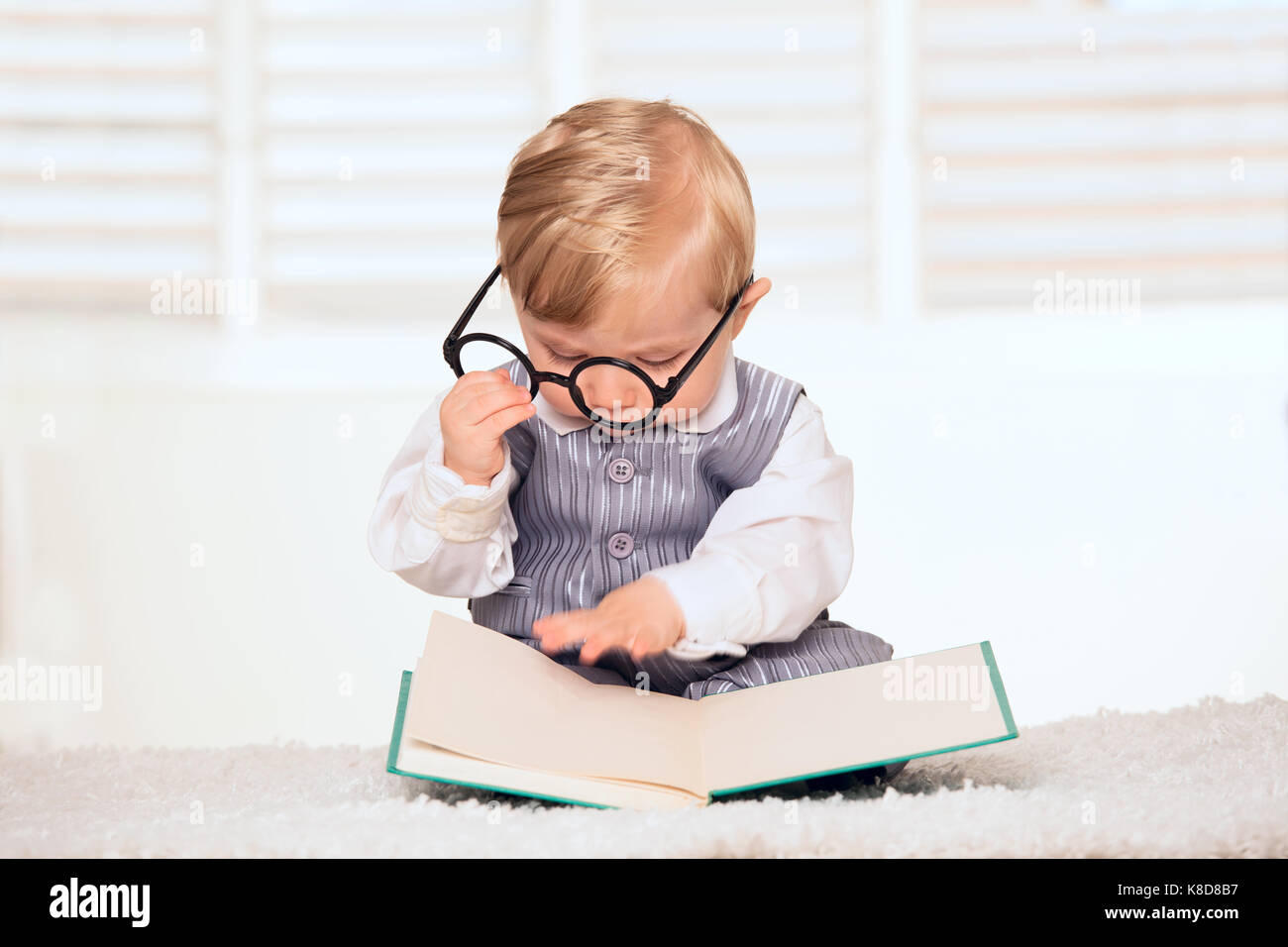 Nerdy baby boy reading a book Stock Photo Alamy