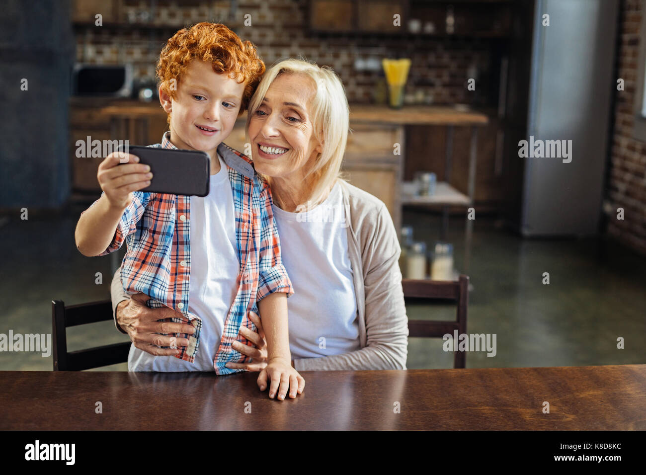 Adorable redhead kid taking selfie with granny Stock Photo