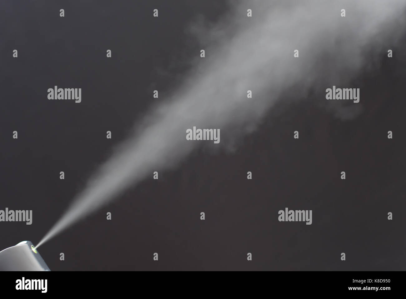 Aerosol spraying with black background Stock Photo - Alamy