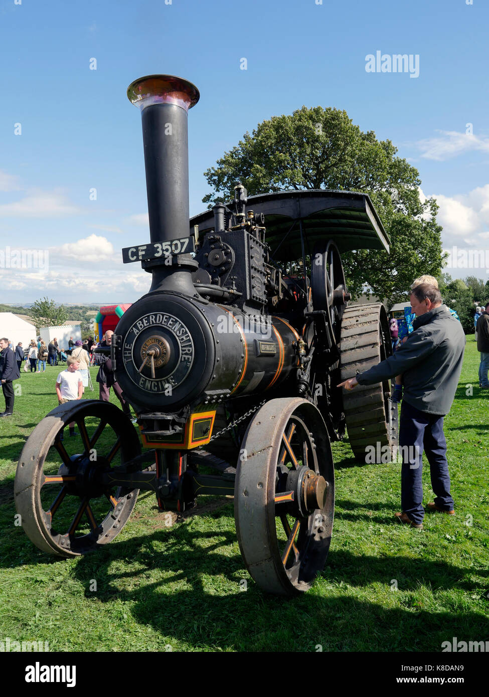 Man carrying child pointing at a traction engine Debyshire England Stock Photo