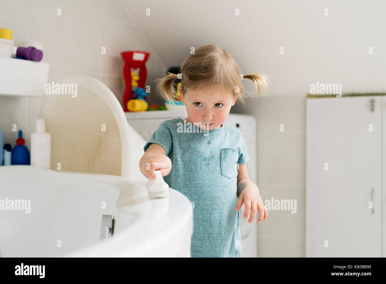 Little girl in bathroom cleaning bathtub with a brush Stock Photo Alamy