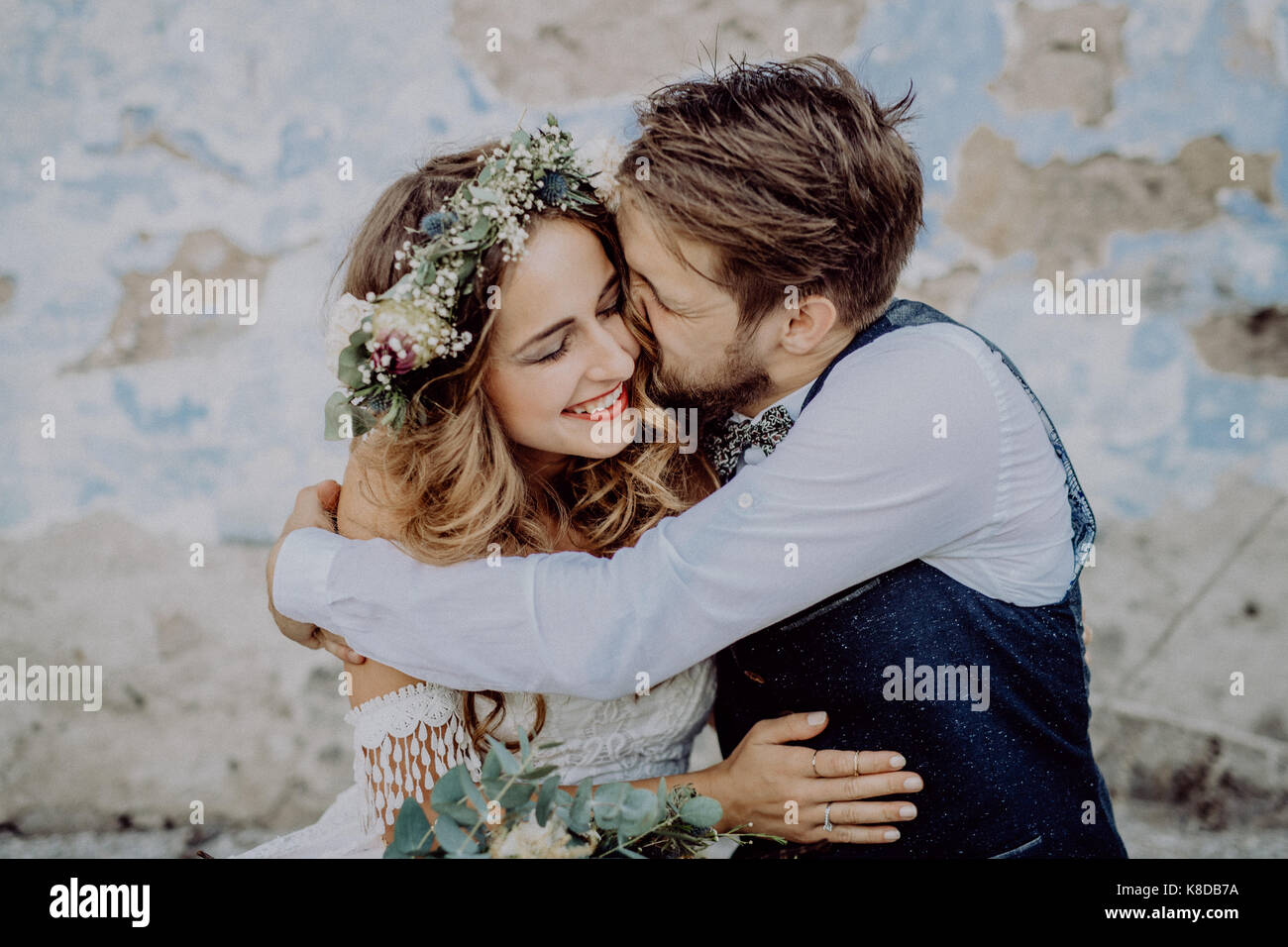 Beautiful bride and groom in front of old shabby house. Stock Photo