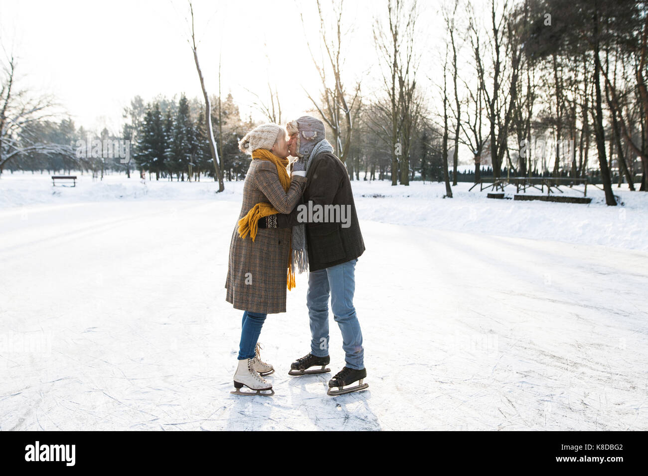 Senior couple in sunny winter nature ice skating. Stock Photo