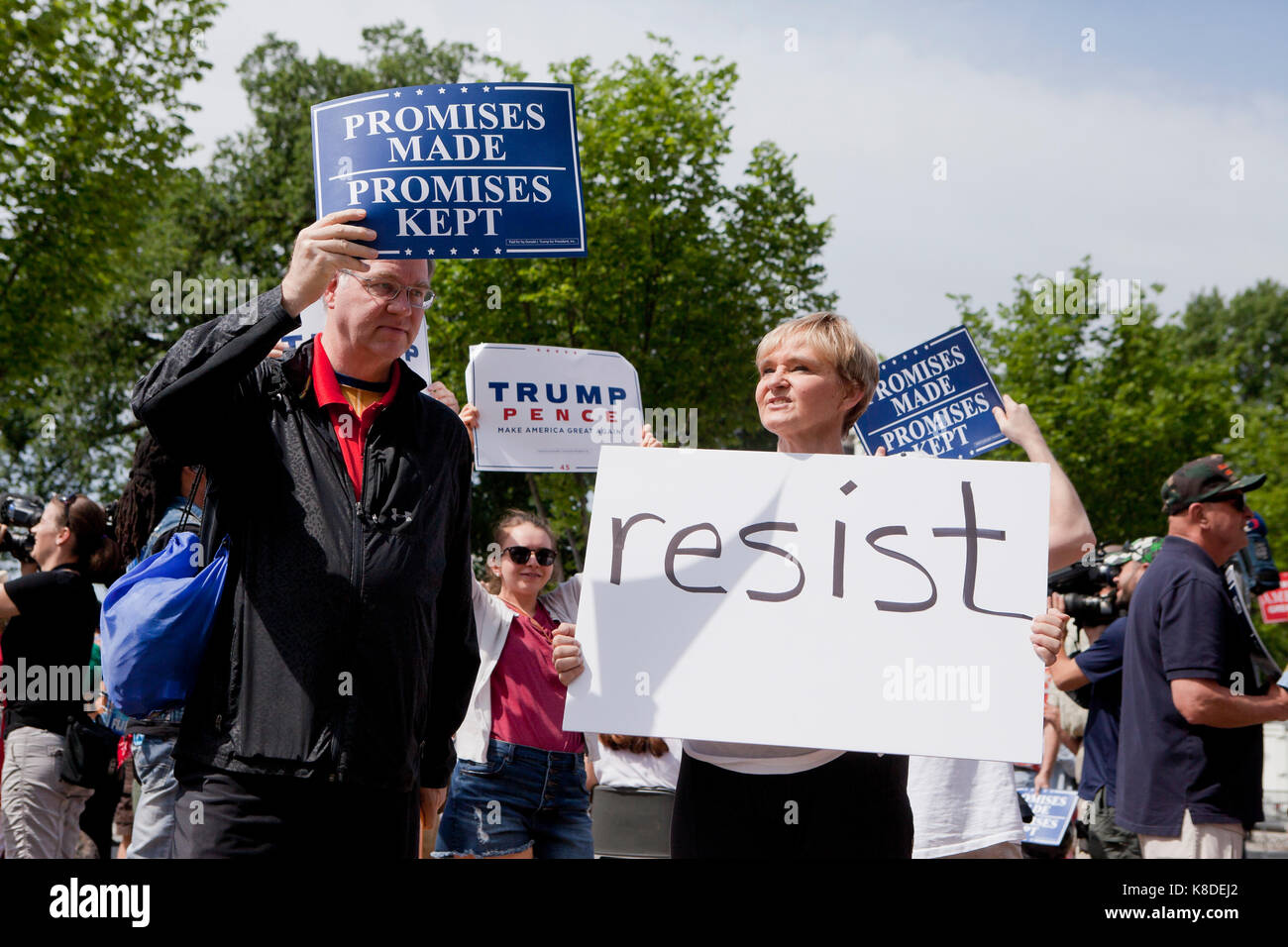 Anti-Trump protester holding 'Resist' sign at a pro-Trump rally - Washington, DC USA Stock Photo