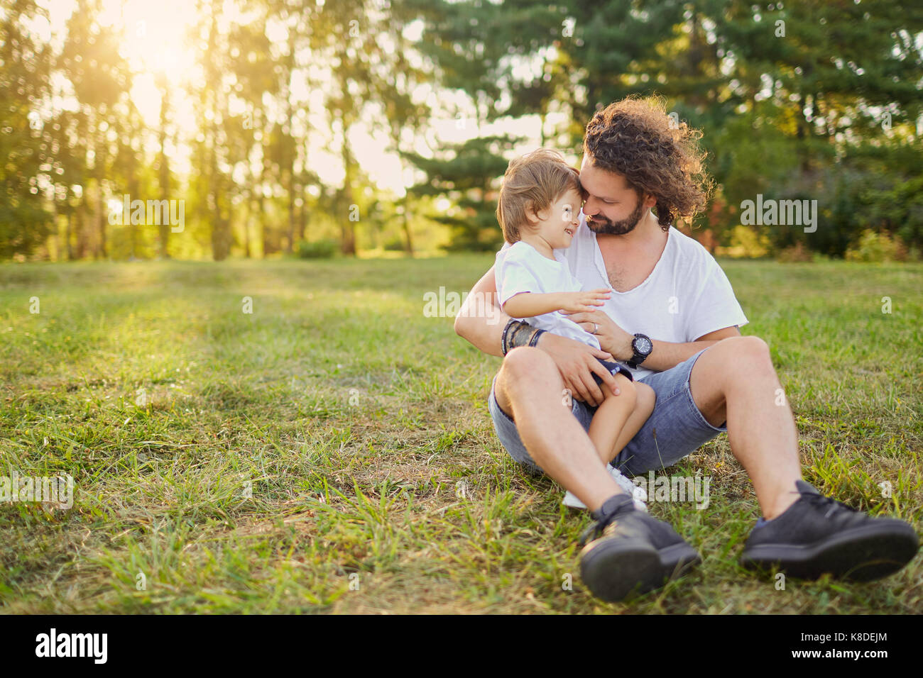 Father son hugging on the grass in the park Stock Photo - Alamy