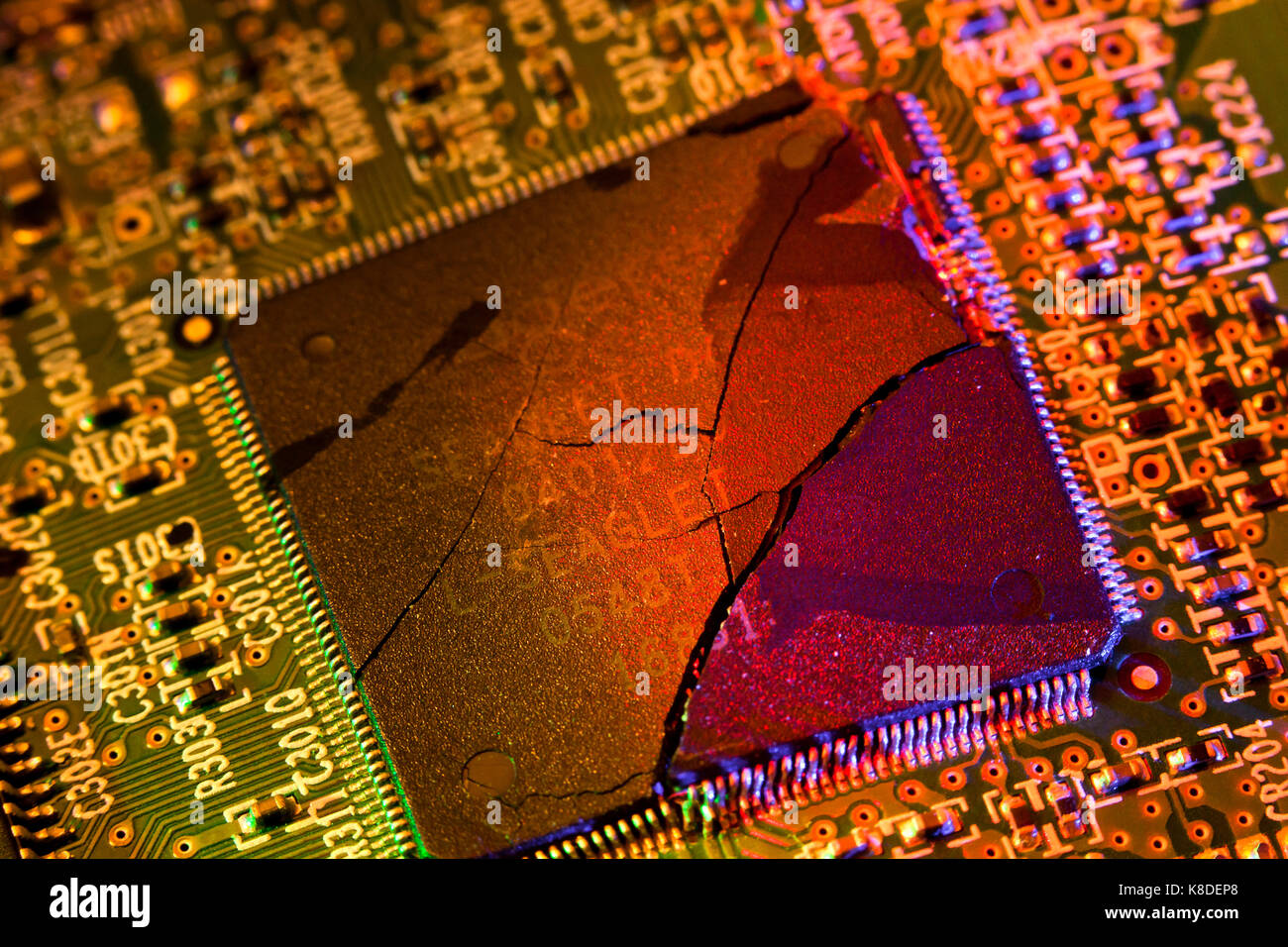 Cracked CPU (broken processor chip, broken CPU) on circuit board - USA Stock Photo