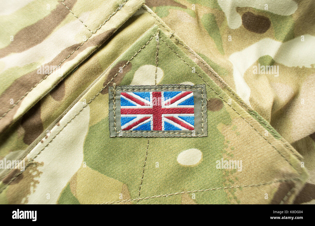 Union Jack / union flag badge on a camouflage British army uniform. Text / writing space surrounding badge. Stock Photo