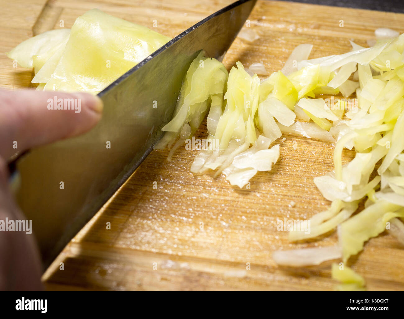 Slicing cabbage with a sharp knife for lunch closeup Stock Photo Alamy