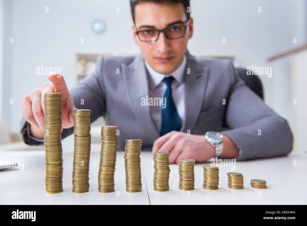 Businessman with golden coins in business growth concept Stock Photo ...