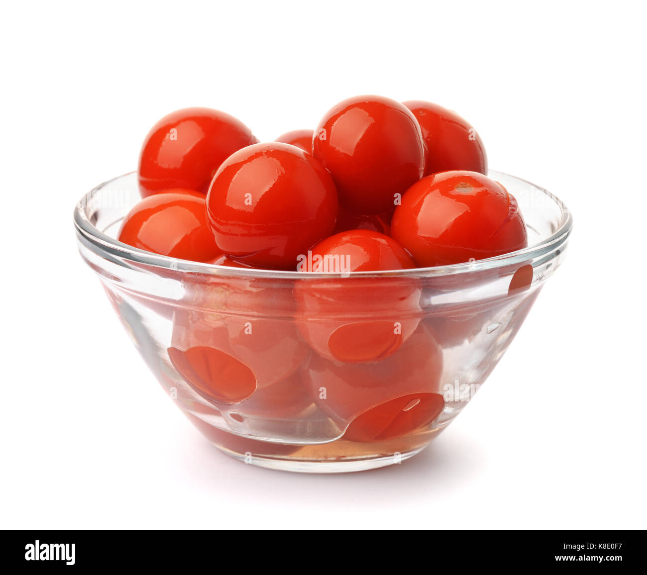 Pickled tomatoes in glass bowl solated on white Stock Photo