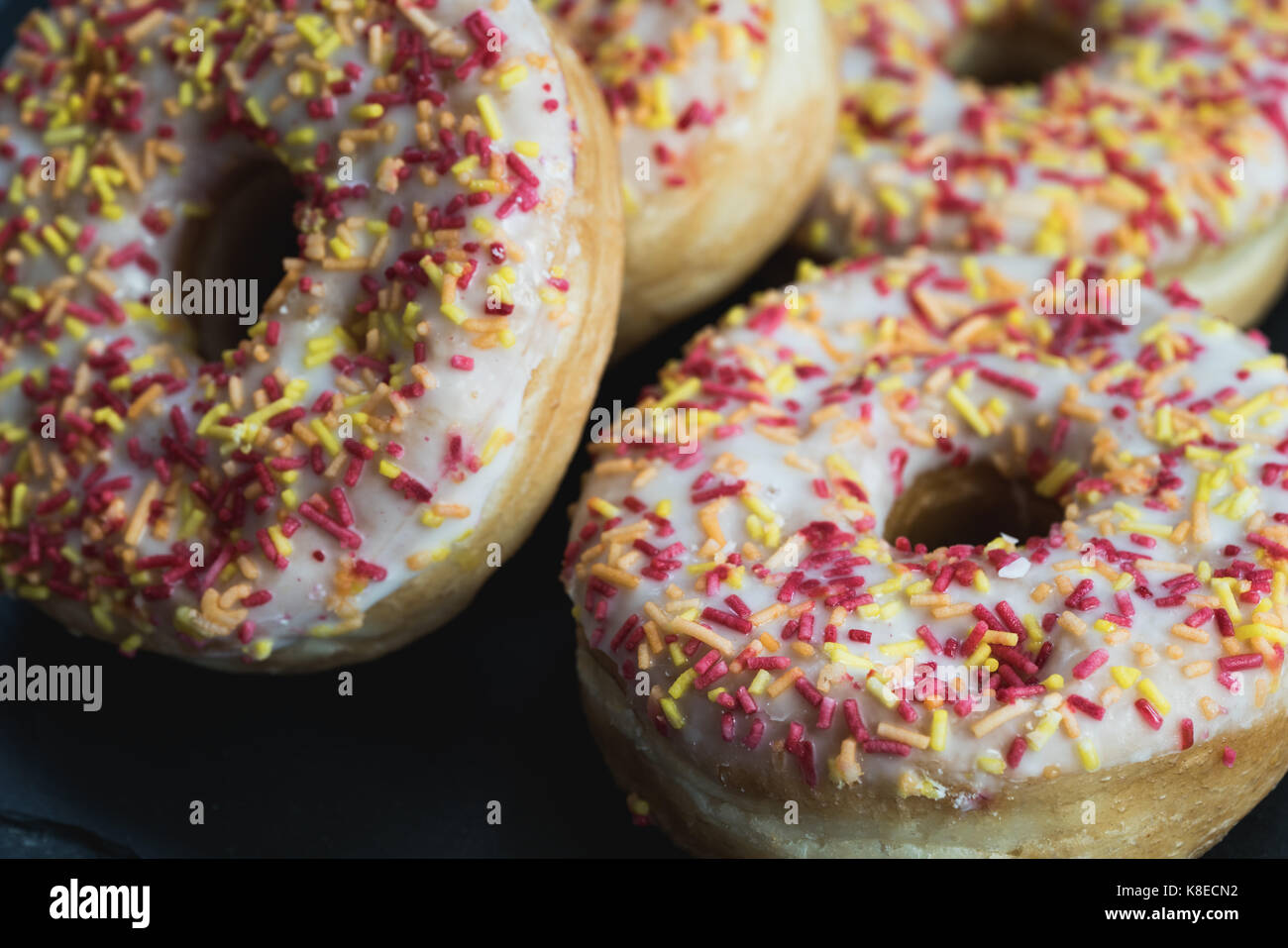 A close shot of four donuts on a slate. Stock Photo