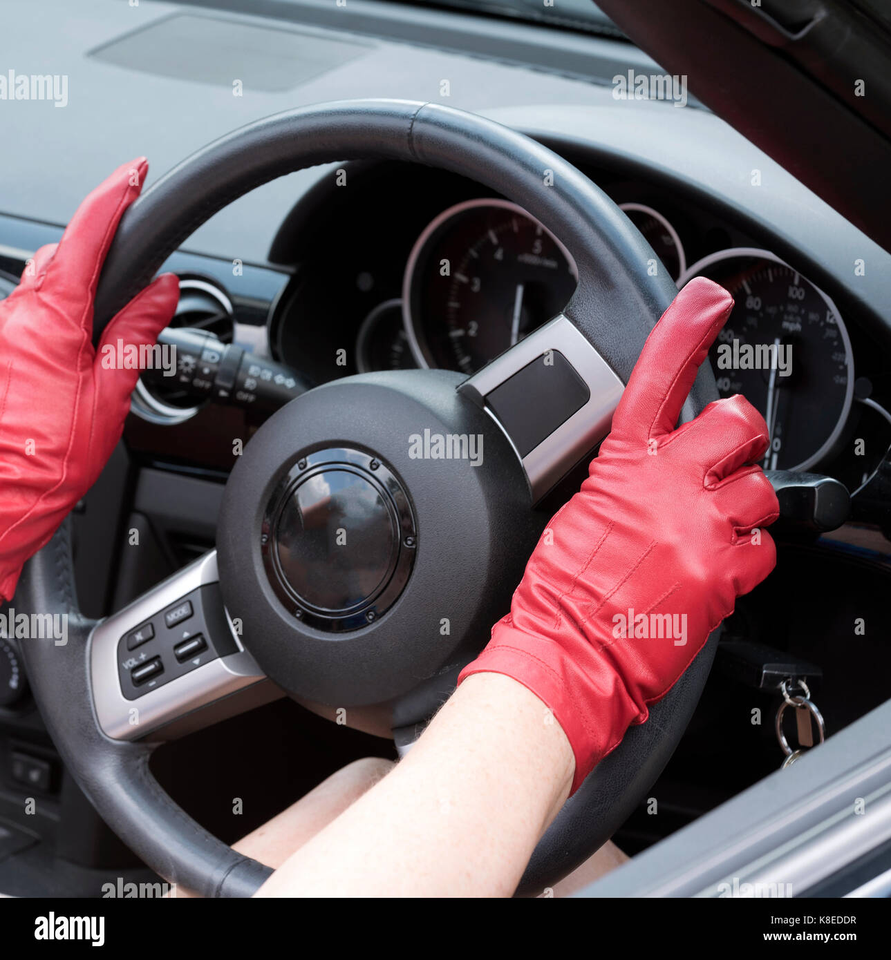 Red leather gloves holding a steering wheel Stock Photo