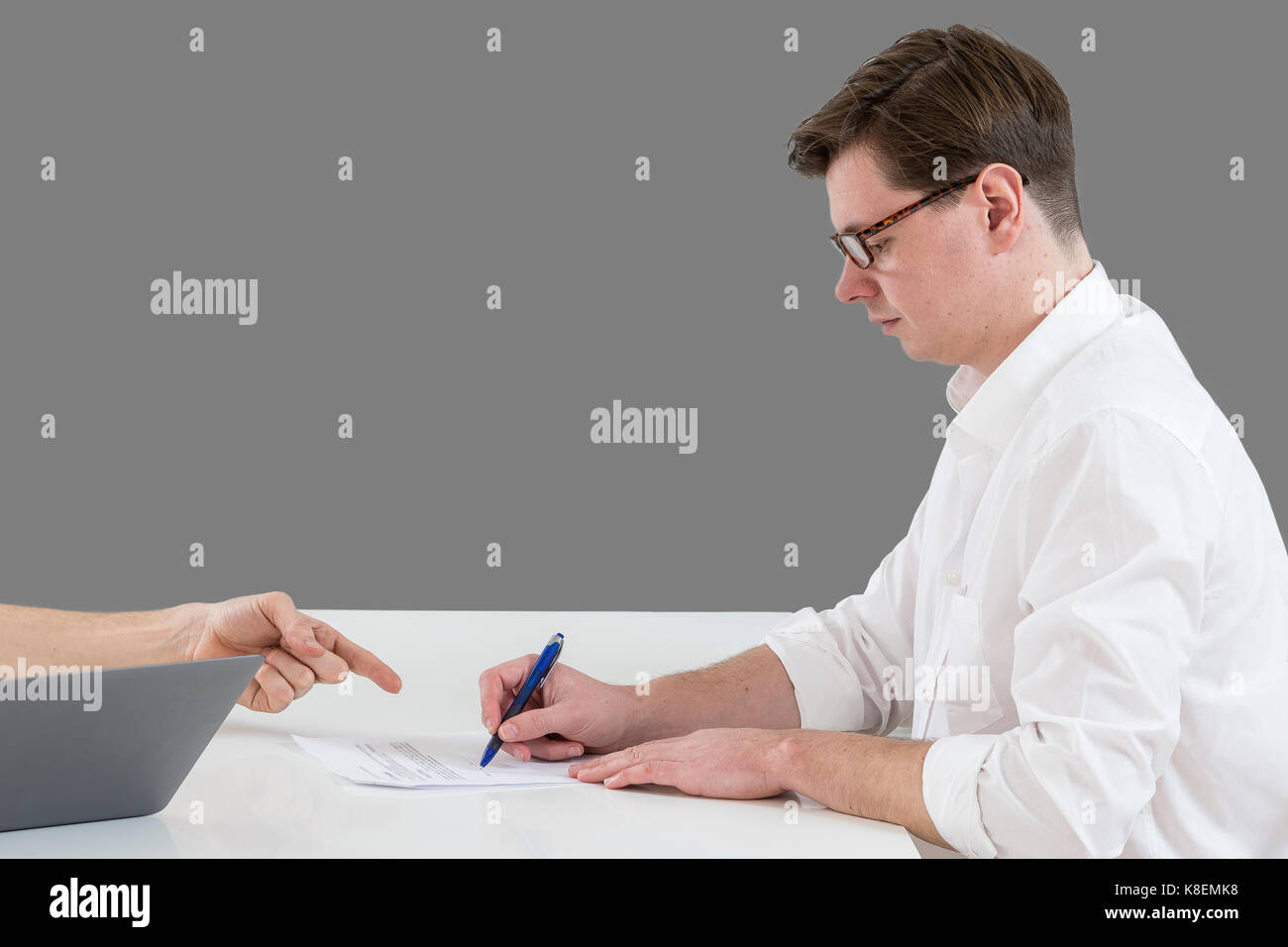 Closeup of male hand pointing where to sign a contract, legal papers or application form. Stock Photo