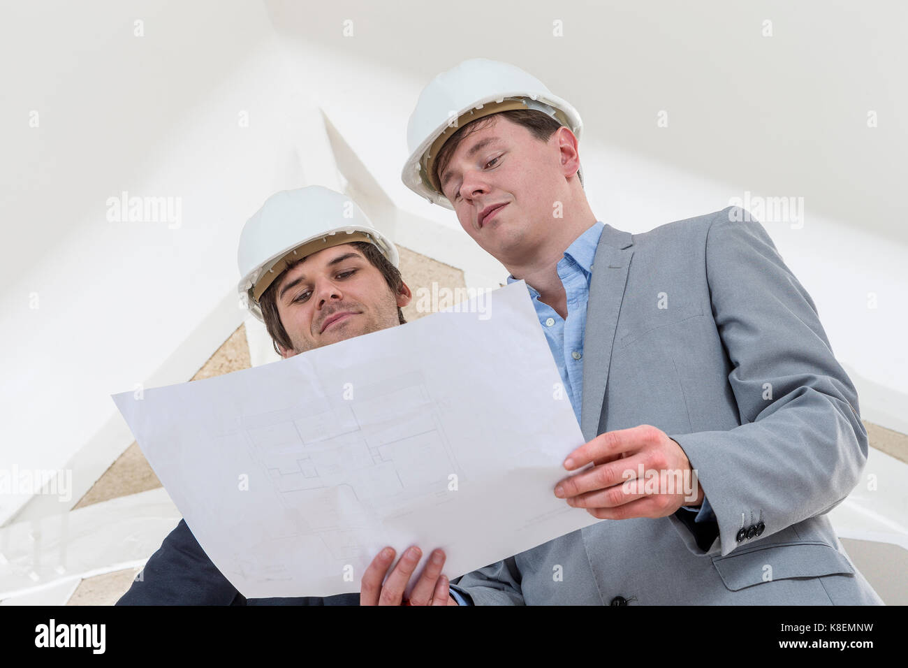 Two Engineer or Architect discuss on Modern Building Project at Construction site in Urban City Stock Photo