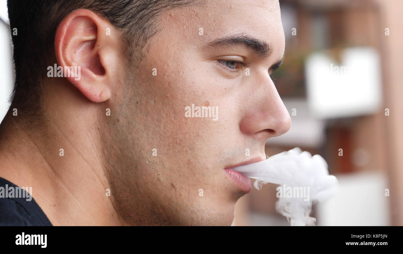 Man smoking ecig on balcony Stock Photo