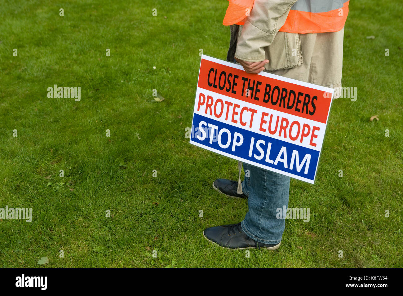 A man is holding a protest sign during an anti islam demonstration of Pegida. Pegida is a group of people who are against the islamization of Europe. Stock Photo